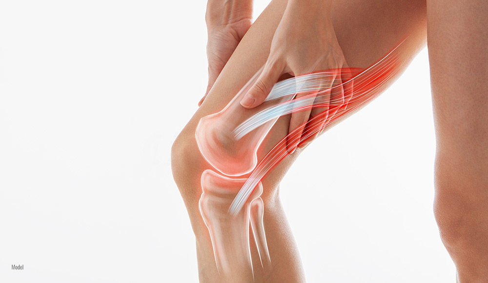 male folding this knee with both hands becuase of Osteoarthritis pain